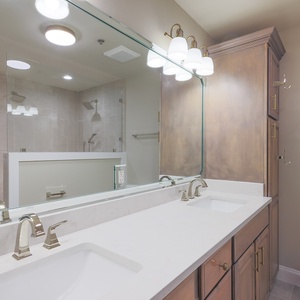 Experience this stylish master bath featuring dual sinks, elegant fixtures, and a spacious walk-in shower for your comfort