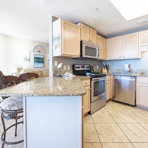 Prepare meals in the kitchen, featuring granite countertops, stainless appliances, coffee maker and a Keurig