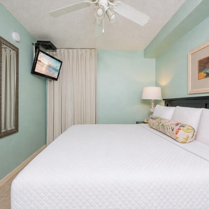 Fluffy pillows invite you to relax in the king suite for a calm movie night after a fun day at the beach