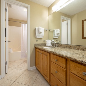 Experience a spacious master bath with a granite countertop, ample storage, and a relaxing atmosphere for your stay