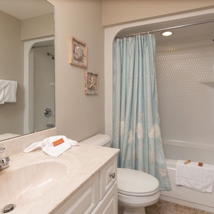 Experience refreshing moments in this guest bath, surrounded by soft towels before beach adventures
