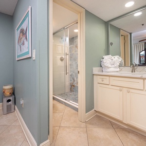 The master bathroom features a sleek walk-in shower, stylish cabinetry, and fresh towels for a rejuvenating stay