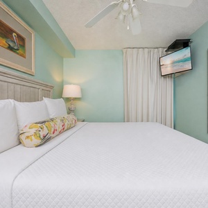 Fluffy pillows invite you to relax in the king suite for a calm movie night after a fun day at the beach