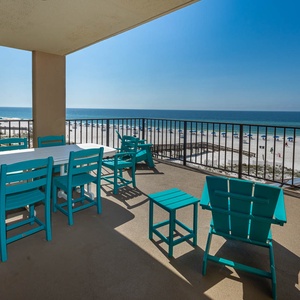 This balcony features bright turquoise furniture and offers breathtaking views of the pristine sandy beach