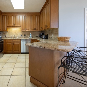 Prepare meals in the spacious kitchen featuring granite countertops and stainless steel appliances, with seating at the bar