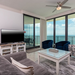 Inviting living area with sofa with full sleeper, twin sleeping chair, and a large TV, perfect for relaxing after a beach day