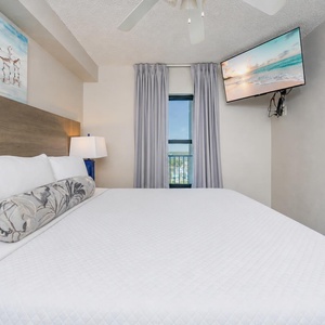 Fluffy pillows invite you to relax in the king suite for a calm movie night after a fun day at the beach