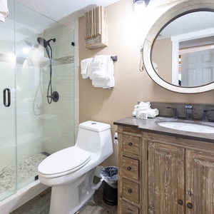 Modern master bath featuring a glass walk-in shower, rustic wooden vanity, and plush towels for a refreshing retreat
