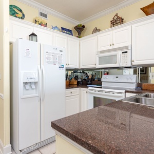 The kitchen features white cabinets, granite countertops, and modern appliances, perfect for preparing meals during your stay