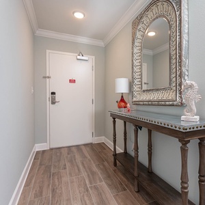 Step into a serene entryway featuring a stylish table and vibrant decor, setting a warm welcome for your getaway