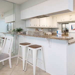 Bright and inviting kitchen with granite countertops, bar seating, and a cozy dining area perfect for meals and gatherings