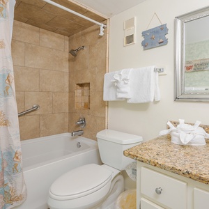 Indulge in a soothing soak in the relaxing tub in the master bath, surrounded by sandy hues and beach accents