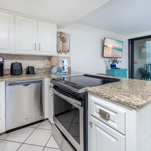 Kitchen with stainless appliances, coffee station, and a gorgeous view of the beach from the adjacent living area