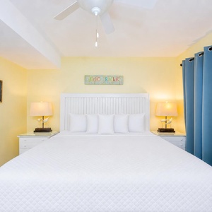 Light from bedside lamps creates a calm mood in the king suite with coastal accents