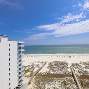 Expansive beachfront view showcases the inviting white sand and gentle waves, perfect for a relaxing vacation getaway