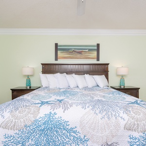 Relax in this master bedroom featuring a plush king bed, coastal-themed decor, and a workspace for your convenience
