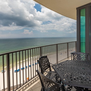 Savor the fresh gulf air while dining on the balcony, featuring a table and chairs with views of the beach below