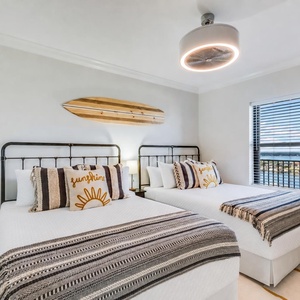 Experience restful nights in this inviting guest bedroom with two queen beds, stylish decor, and view to brighten your day