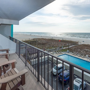 Enjoy relaxing beachfront views from this inviting balcony, perfect for relaxation with comfortable seating