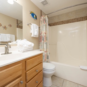Refresh in the guest bathroom featuring a spacious vanity, ample towels, and coastal decor for a cheerful atmosphere
