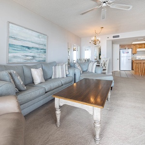 Inviting living area, featuring comfortable seating, a wooden coffee table, and coastal decor