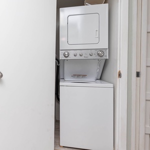 The laundry area features a stacked washer and dryer, providing convenience for guests during their stay