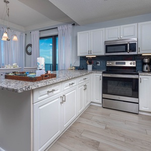 Enjoy cooking in this stylish kitchen with stainless appliances, granite counters, and a beachfront view