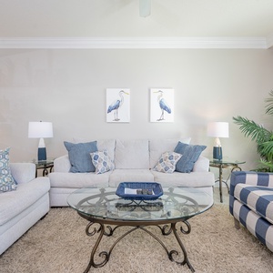 Embrace relaxation in the airy living area, where plush seating invites you to unwind with a good book or favorite show