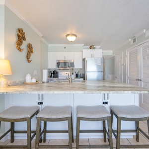 Kitchen features stainless appliances, elegant and spacious countertops, and stylish seating for a cozy dining experience