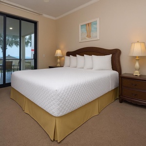 Retreat to the king master suite with cozy bedding and drift off to the sound of the waves from the patio