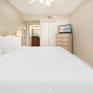 Plush king bed beckons you to unwind with a good movie in the guest suite comfort