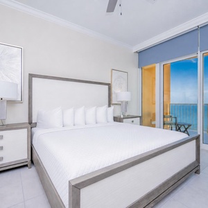 Retreat to the king master suite with cozy bedding and drift off to the sound of the waves from the balcony