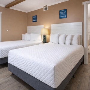 Relaxing guest bedroom featuring two plush double beds, stylish decor, and a convenient guest bathroom access