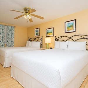 Rest peacefully in soft queen beds after beach adventures, embraced by inviting decor in this guest room