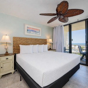 White linens dress the king bed in the master suite where you unwind with coastal views through sliding glass doors