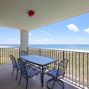 Spacious balcony with a dining table and chairs offers a direct view of the beach and the tranquil Gulf waters