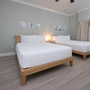 Admire coastal prints over the headboards in this queen guest room for a relaxing retreat