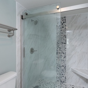 Master bath featuring a sleek walk-in shower with a glass door and stylish stone accents, complemented by a modern towel rack
