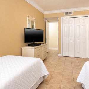Cheerful guest room with two twin beds, a TV, and a charming decor, perfect for a restful getaway