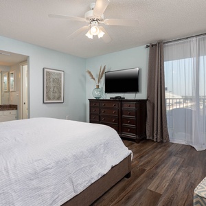 Relax in the serene master bedroom featuring a king bed, a TV, and cozy seating for a relaxing stay