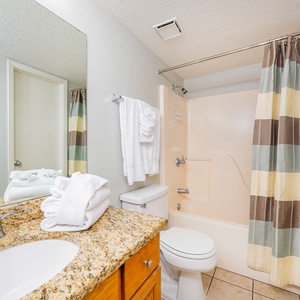 Towel stacks invite you to refresh and unwind in this bathroom after your day along the coast