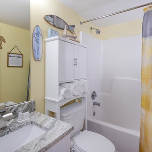 The master bathroom features yellow walls, a stylish granite countertop, and decorative accents for a cheerful atmosphere