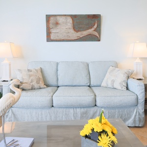 Relax on the soft sofa surrounded by coastal decor, with a charming centerpiece and warm lighting