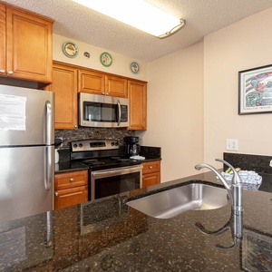 This kitchen features stainless appliances, granite countertops, and a stylish design, perfect for meal preparation