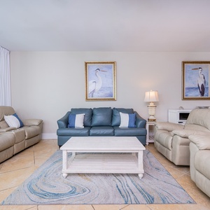 Inviting living area featuring plush seating, coastal artwork, and a light, airy atmosphere