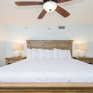 Bright and airy guest bedroom featuring a king bed, complemented by warm wood furnishings and soft lighting