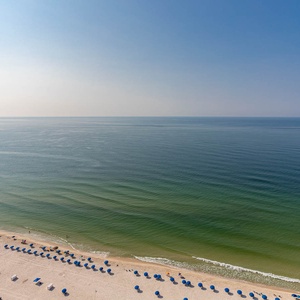 Imagine strolling the beachfront, watching neat rows of blue umbrellas and hearing gentle gulf waves