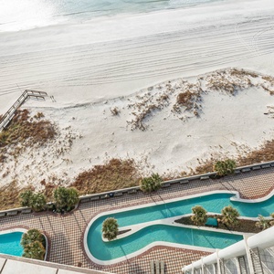 This balcony view showcases a tranquil beachfront with the lazy river and waterslide below, perfect for relaxation and fun