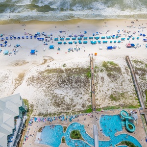 Discover the inviting pool area with gradual entry, a refreshing lazy river, and fun waterslide on the beach