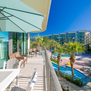 Breathe in the fresh coast air from the balcony while enjoying a refreshing drink beneath the sunlit umbrella